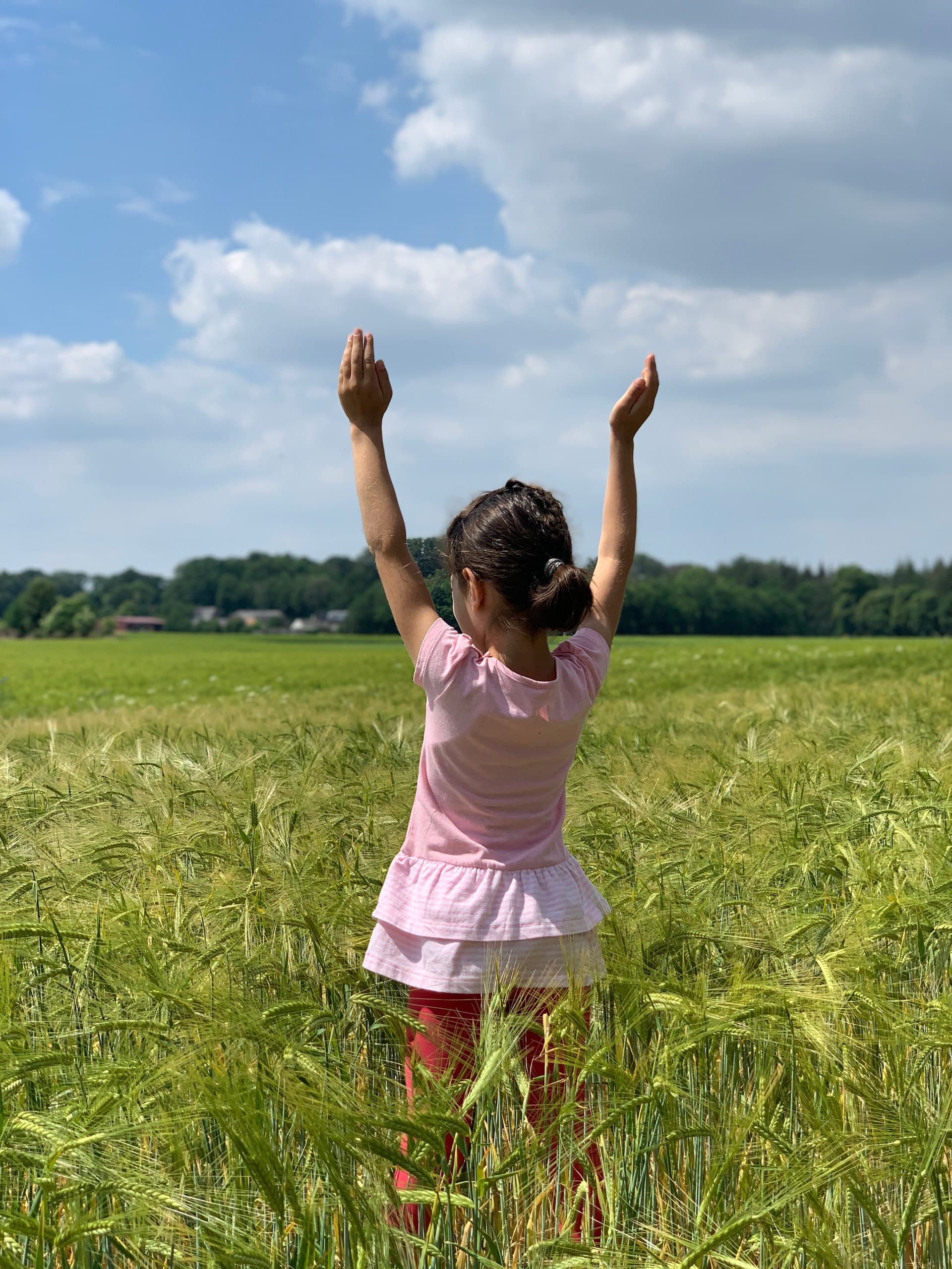 Kind beim Yoga in einem sommerlichen Feld am Wagram